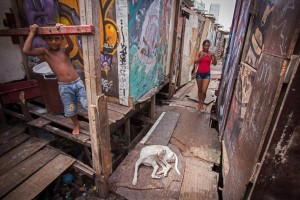 epa05119331 A woman walks at a zone of the shanty town of Beco do Sururu, located close to Boa Viagem, the richest neighborhood of city of Recife, Brazil, 22 January 2016.  Recife is the Brazilian city with more cases of Zika virus. Brazilian government have organized a group of 250,000 people between militarymen and health authorities to try to erradicate the mosquito that transmit the virus.  EPA/Percio Campos