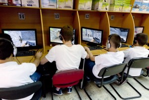 Palestinian youth play PC games at internet cafe in Jerusalem