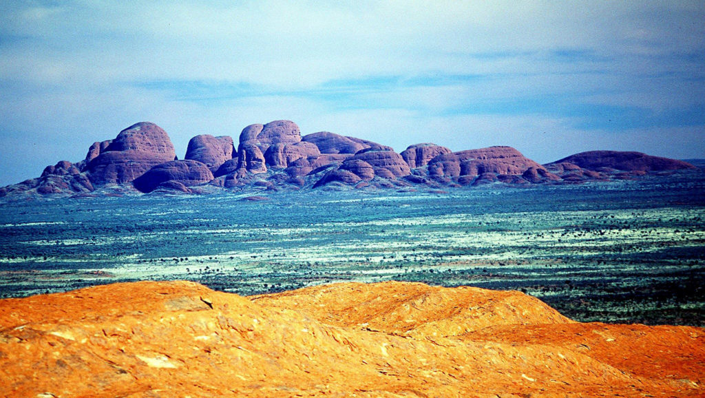 Φωτογραφία τραβηγμένη από την κορυφή του Ουλουρού(FILES) A file photo dated 27 May 1991 of Kata Tjuta (The Olgas) taken from the summit of Uluru (Ayer's Rock), the largest single rock monolith in the world, in central Australia which UNESCO accorded World Heritage listing in 1987. The traditional owners of "The Rock," the Anangu-Pitjantjatjara Aborigines, are now concerned that Uluru and nearby Kata Tjuta are being over photographed and may be losing their cultural significance after receiving a record 300 requests for commercial film and photography permits during 2000 - almost 200 more than in 1999. (FILM) AFP PHOTO/Torsten BLACKWOOD