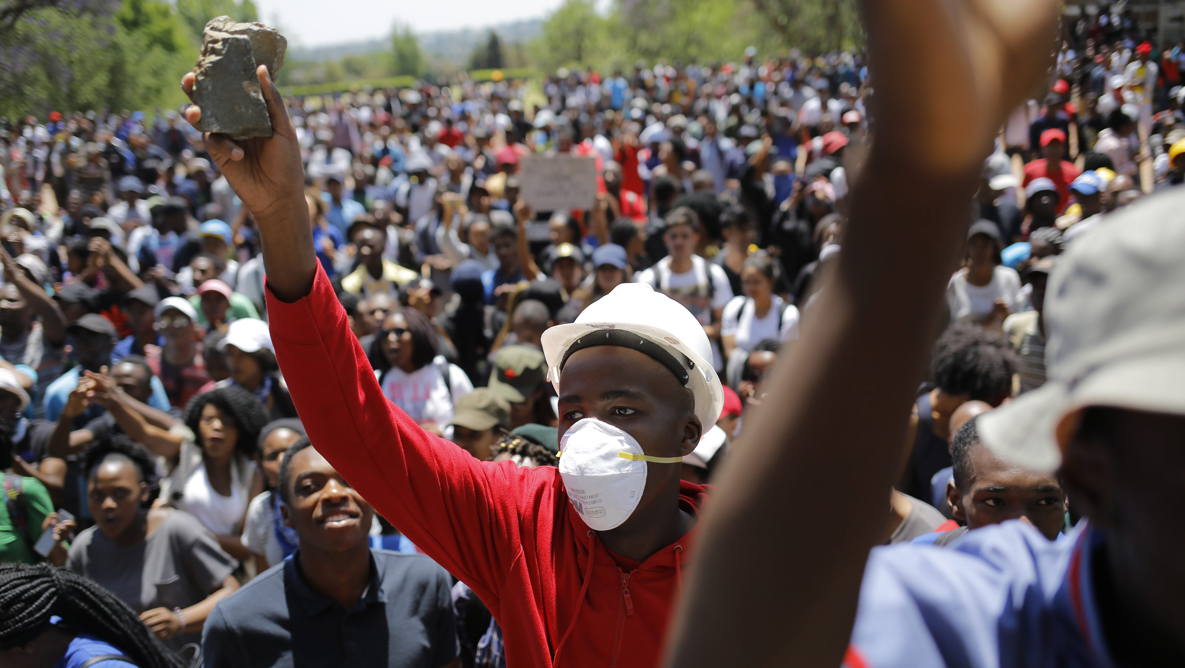 epa05579675 Students from Wits University carry stones while they demonstrate during a fourth week of clashes with police forces during ongoing protests against the cost of higher education in Johannesburg, South Africa, 10 October 2016. The ministry of education announced a 8 percent increase of university fees following calls by student demonstrators of a zero percent increase. The violent protests have spread to many of the countries higher education campuses and have been ongoing for several weeks. EPA/KIM LUDBROOK