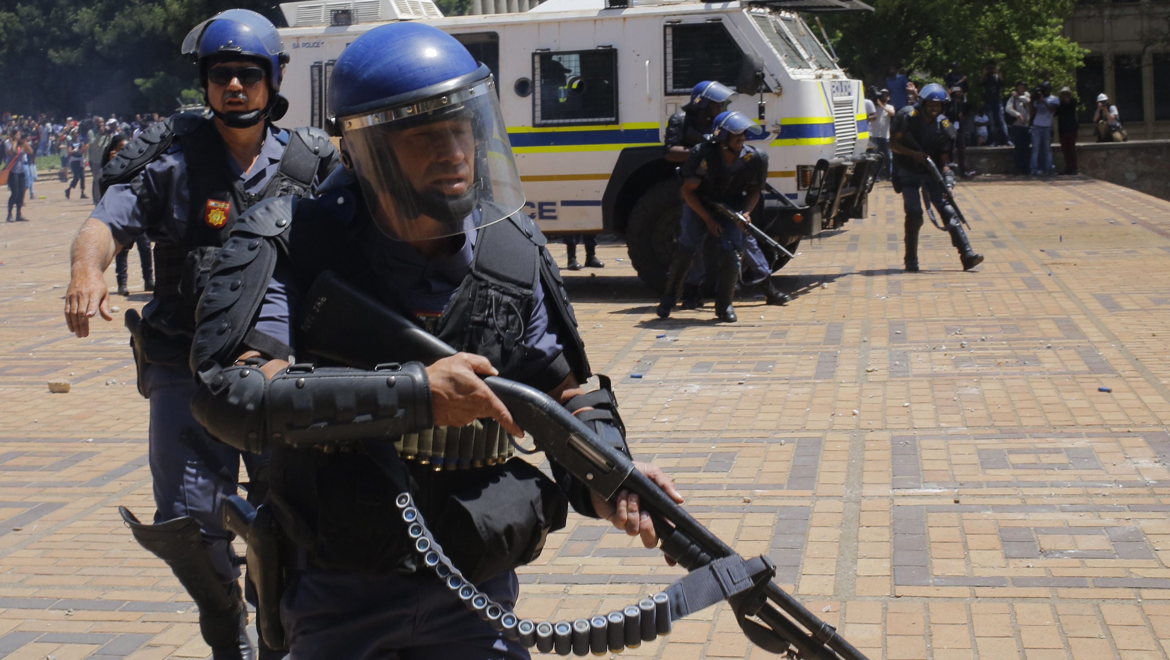 epa05579685 Police forces move into position to shoot rubber bullets at Wits University students during ongoing protests against the cost of higher education in Johannesburg, South Africa, 10 October 2016. The ministry of education announced a 8 percent increase of university fees following calls by student demonstrators of a zero percent increase. The violent protests have spread to many of the countries higher education campuses and have been ongoing for several weeks. EPA/KIM LUDBROOK