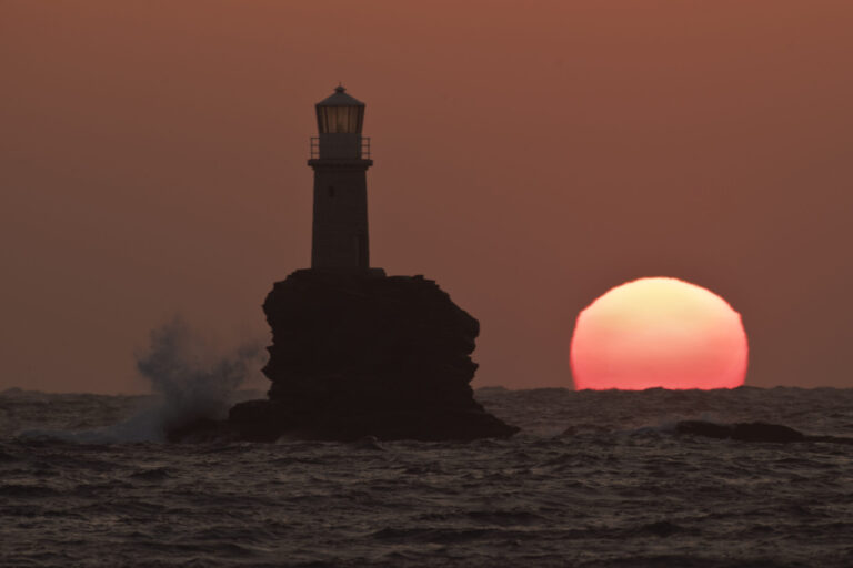Waves hit the 1847 built Tourlitis lighthouse in The Aegean island of Andros, Greece, as the sun rises Friday, March 22, 2019