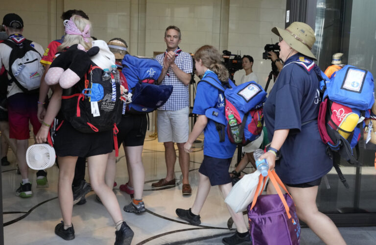 Gareth Weir, center, British Deputy Ambassador to South Korea, greets scout members of his country as they arrive from the World Scout Jamboree campsite at a hotel, South Korea, Saturday, Aug. 5, 2023. South Korea is plowing ahead with the World Scout Jamboree, rejecting a call by the world scouting body to cut the event short as a punishing heat wave caused thousands of British and U.S. scouts to begin leaving the coastal campsite Saturday