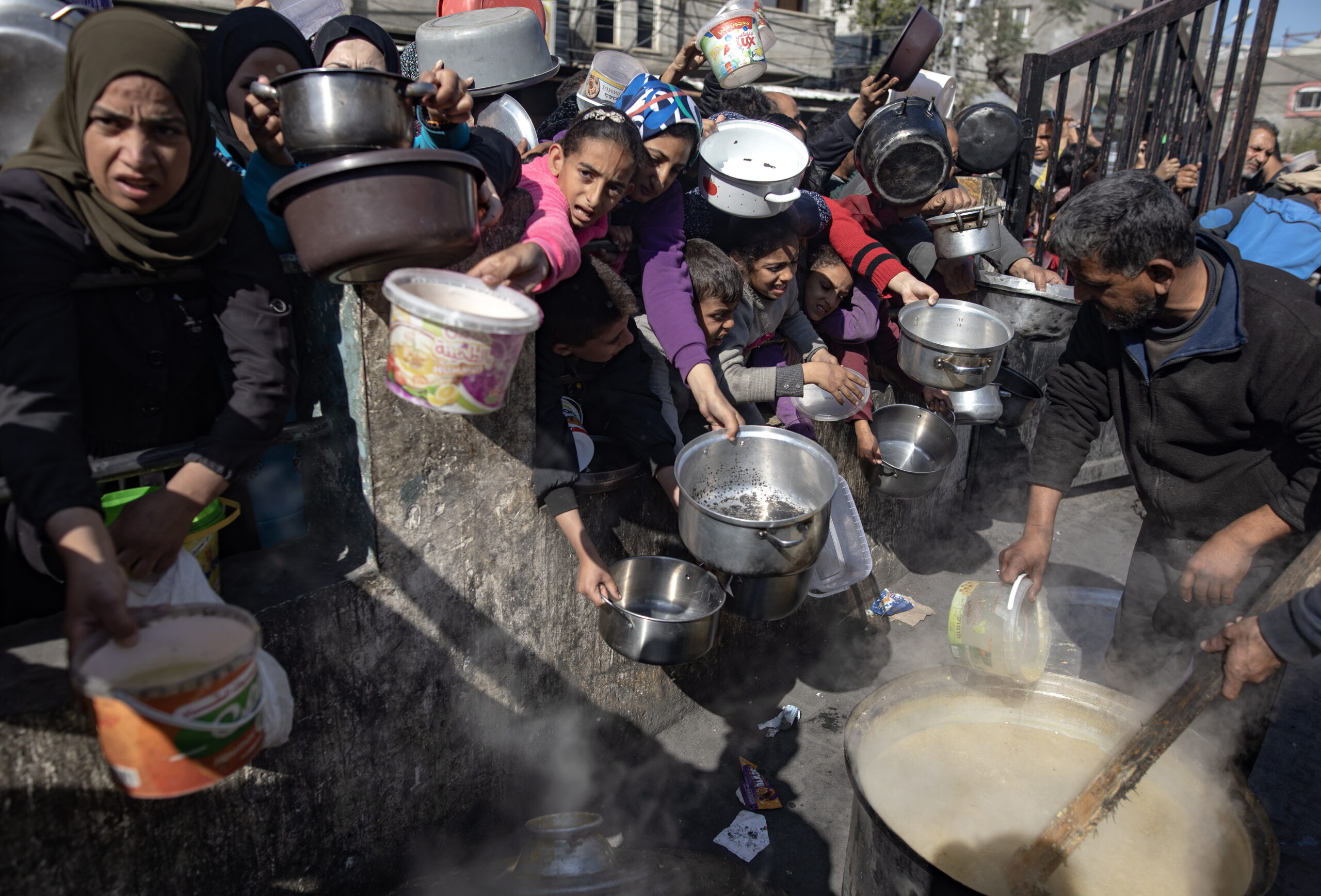 Displaced Paletsinians line up for food aid in Rafah