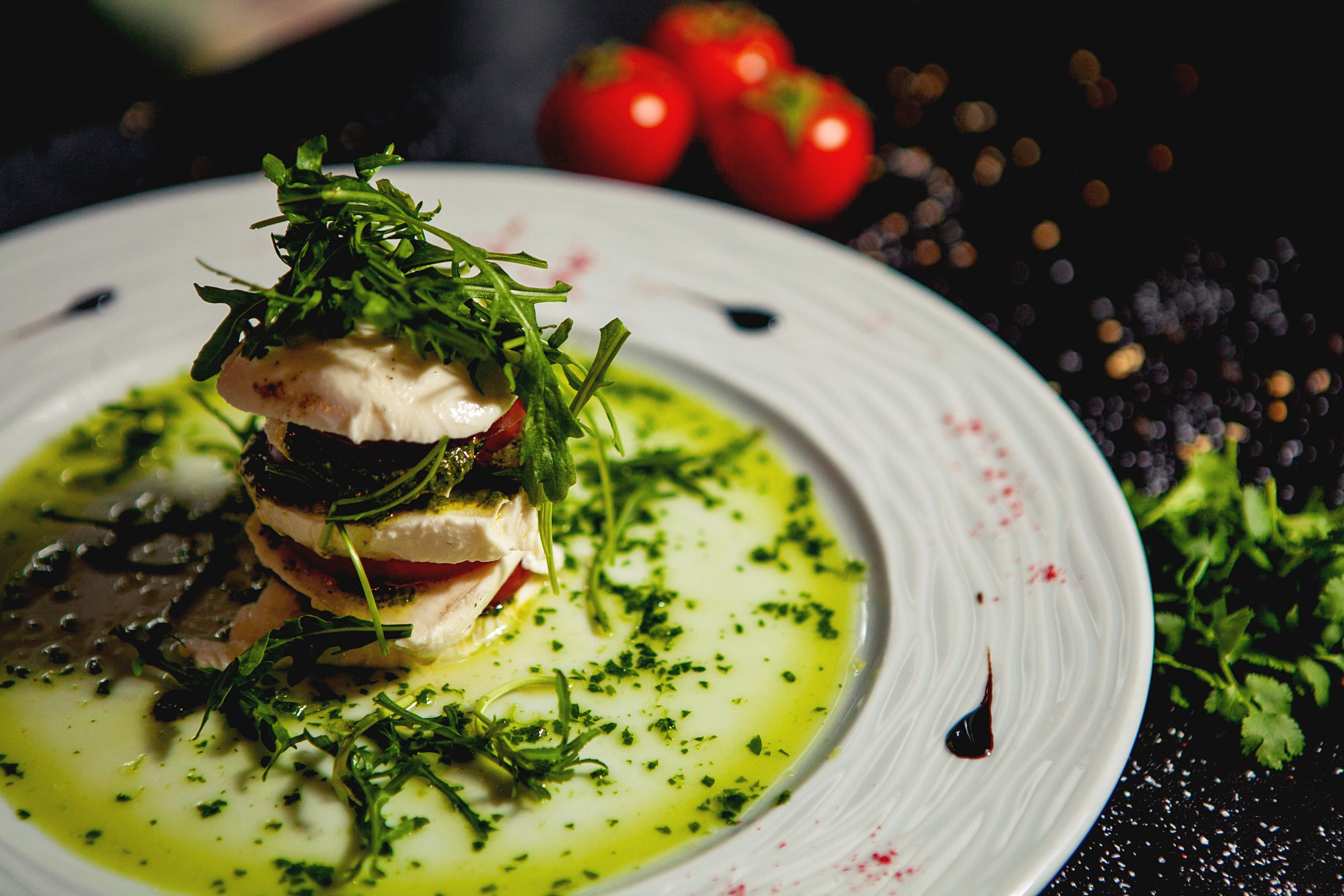 close up of layered carpese salad with mozzarella and tomato and arugula